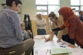 Students in work together over a table in an architecture class 