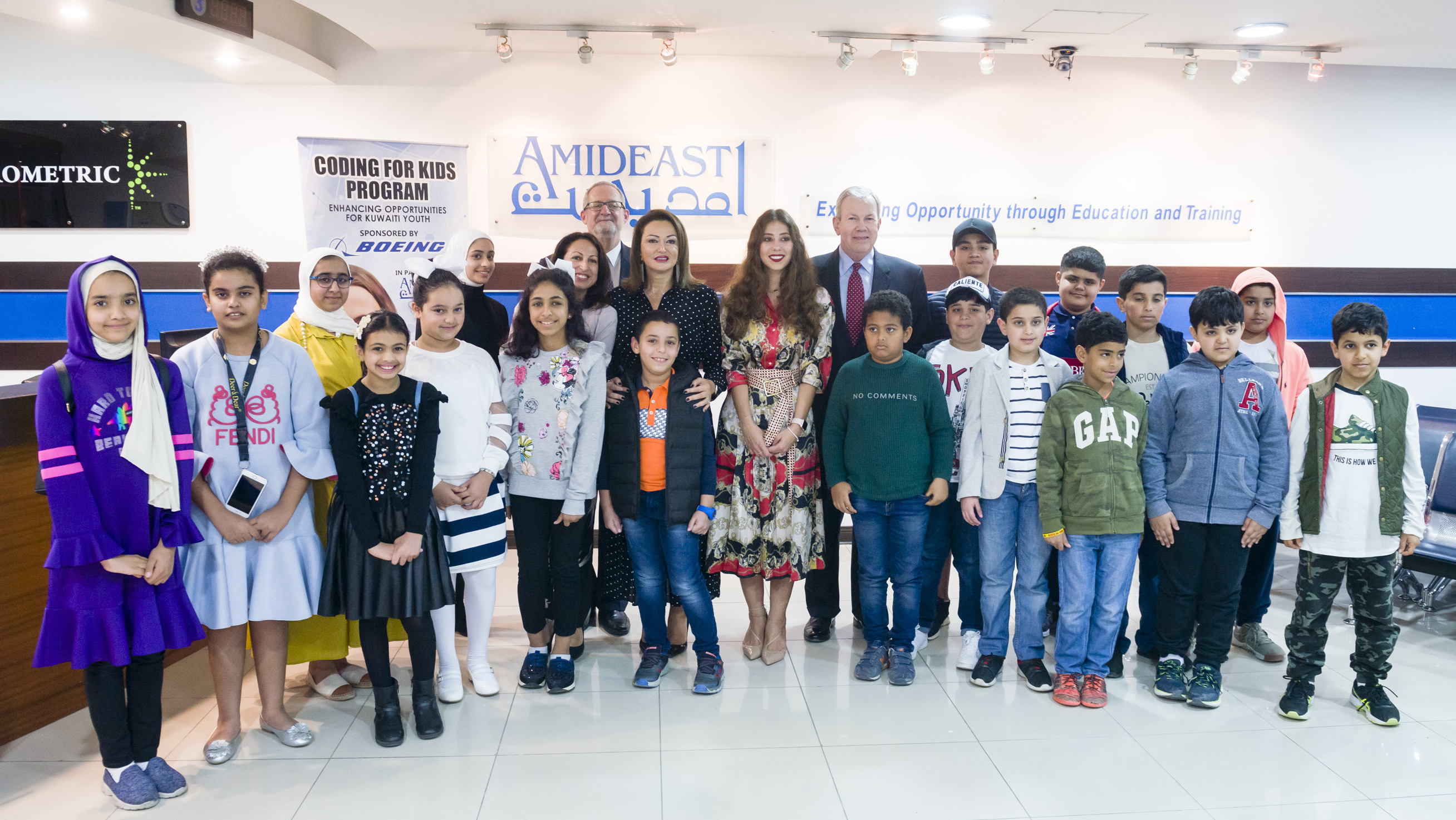 Group of younger students and teachers posing in a classroom