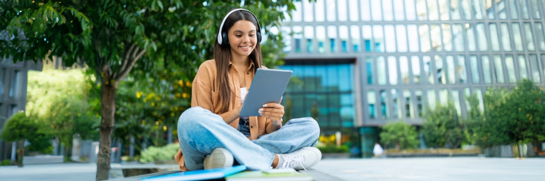 Happy young student using a tablet, smiling and engaged in learning