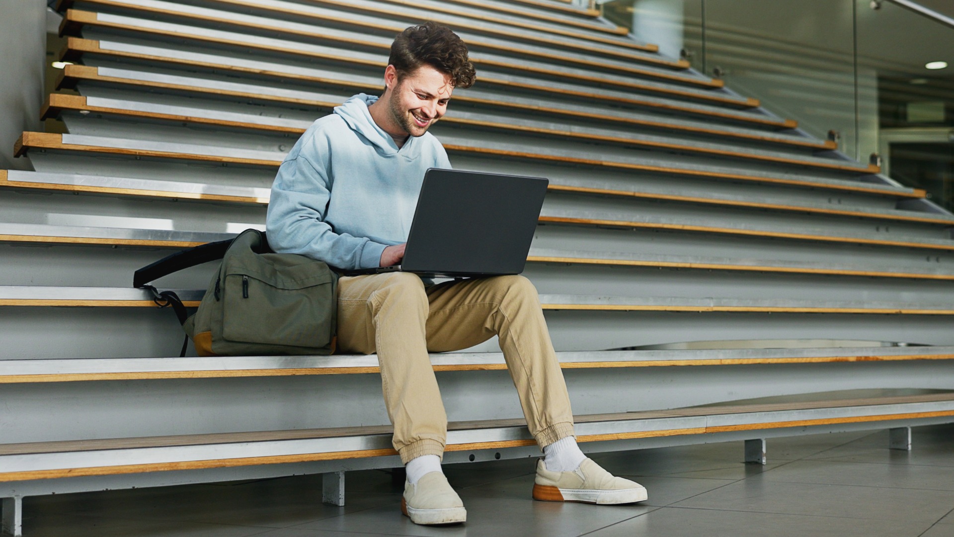 Man, stairs and student on laptop for learning, assignment and books for studying on campus. Male person, online research and university for knowledge, website and registration at college institute