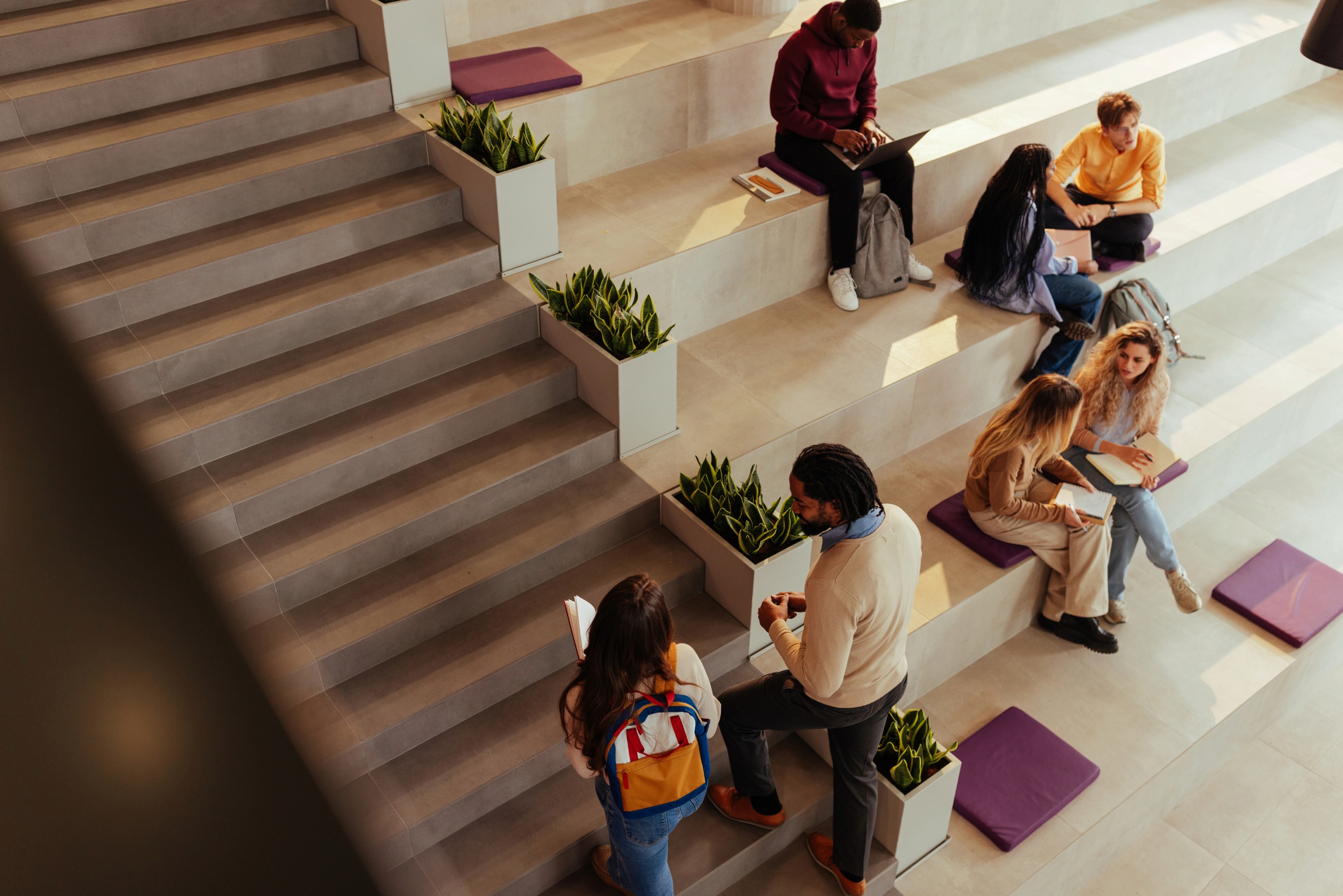 University students studying and walking in modern building hall