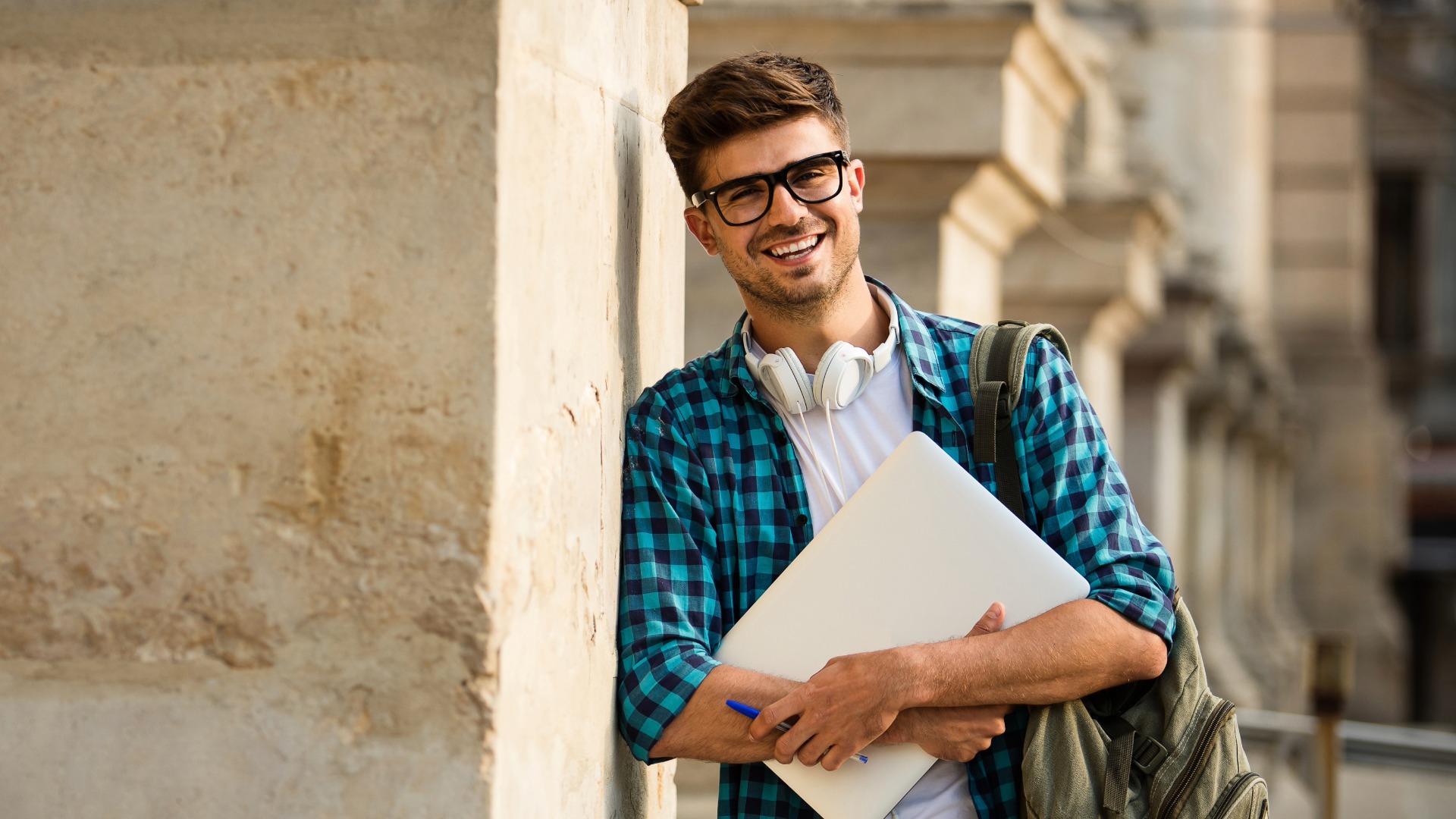 young student leaning on column of university or school