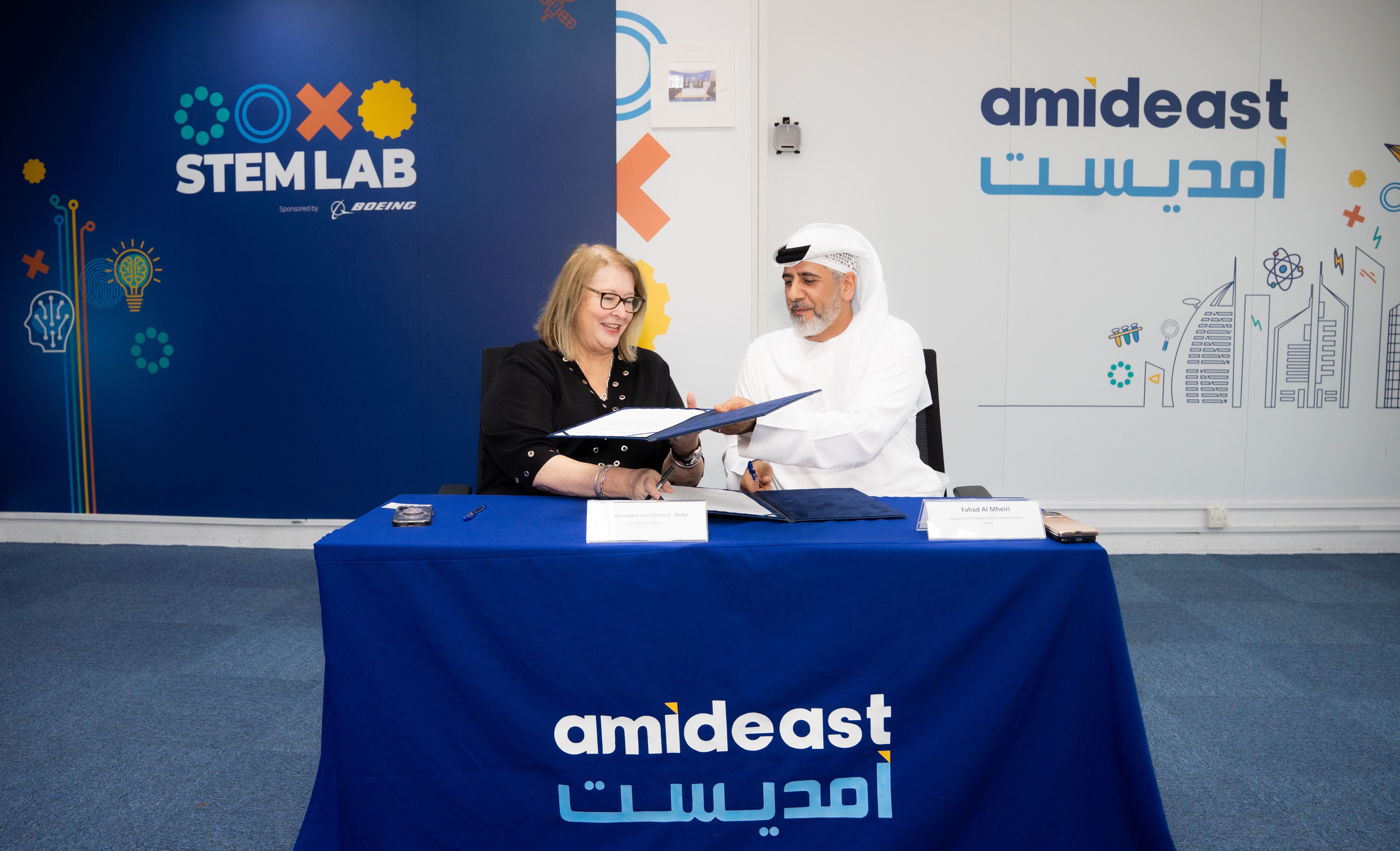 Amideast and Boeing officials at table signing agreement