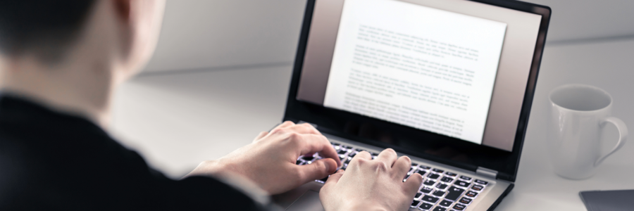 Student writing with laptop. 