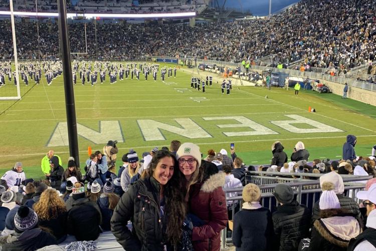 Two students in front of the endzone at a football game