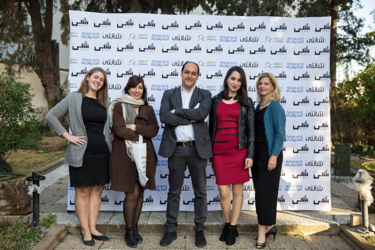 مجموعة من المشاركين في مشروع بناء الجمعيات المحلية للتنمية والابتكار (BLADI) يبتسمون أمام لافتة عليها شعار أمديست