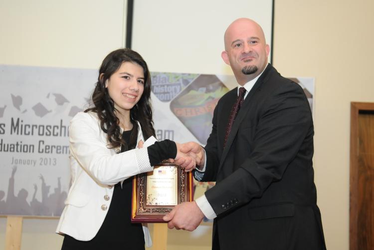 Country director presenting plaque to an Access essay winner
