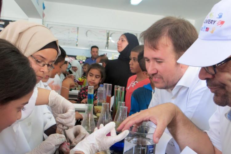 Teachers work with campers as they do a science experiment 