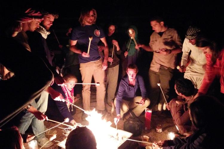 Students roast marshmallows over a fire in Wadi Rum, Jordan