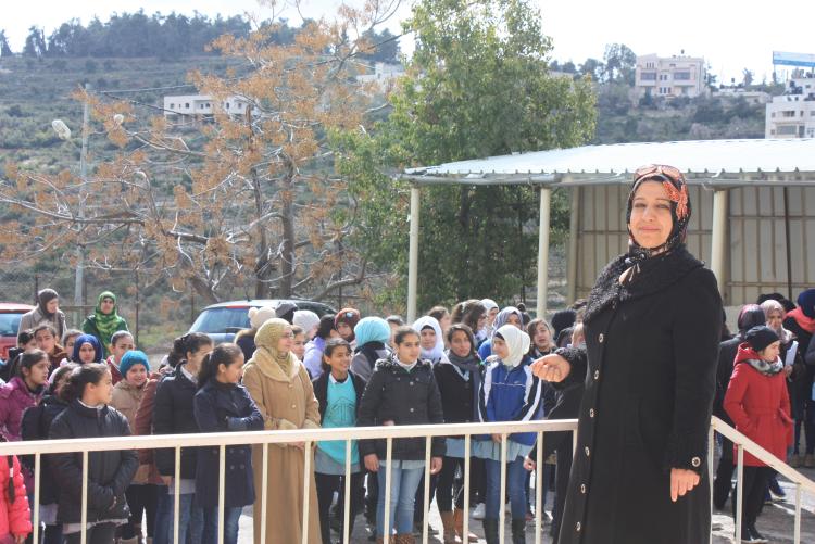 Teacher posing in front of large group of pupils