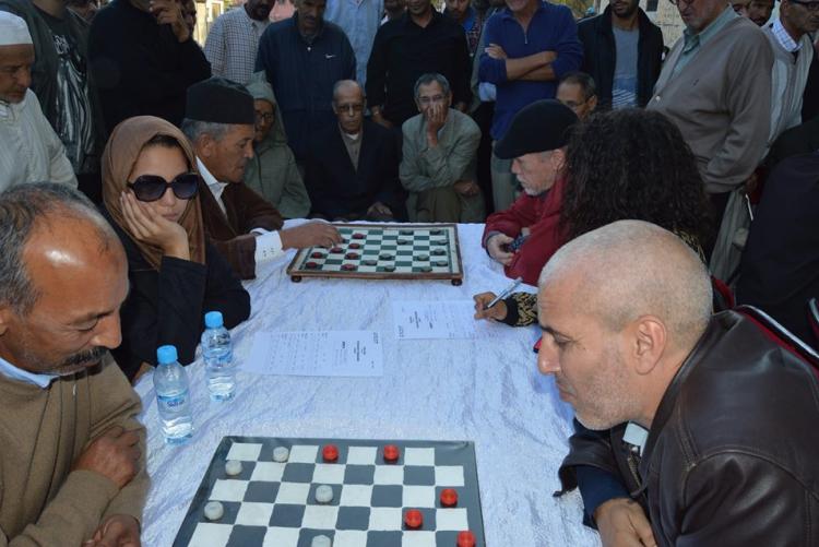 A group of people is playing checkers game