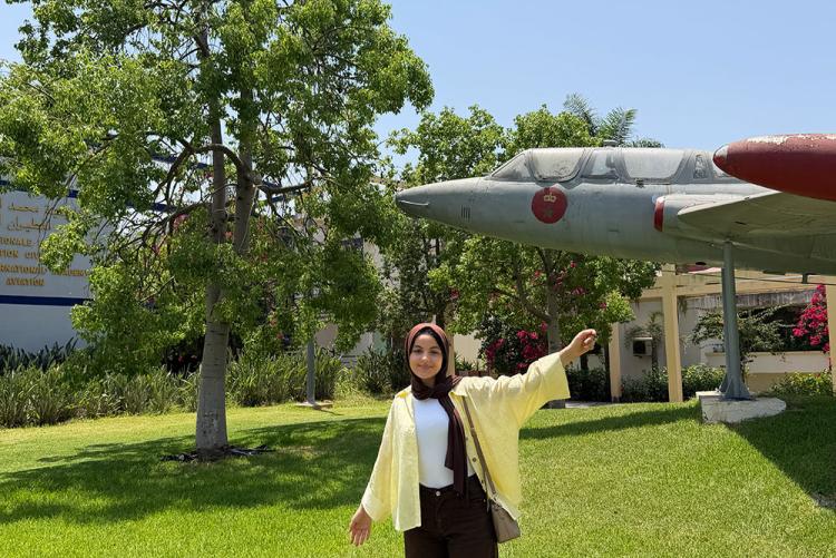 Student taking a photo with an airplane