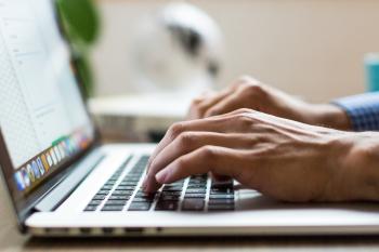 Photo of an adult typing on a laptop