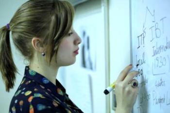 Female student writes on a whiteboard