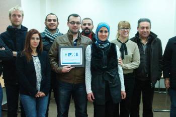 Group of students pose while one holds up a certificate