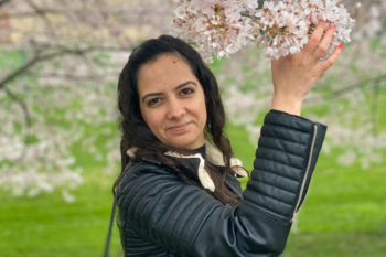 Woman touching a branch with flowers.