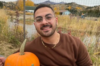 Man posing with pumpkins.