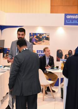 people at conference exhibit booth